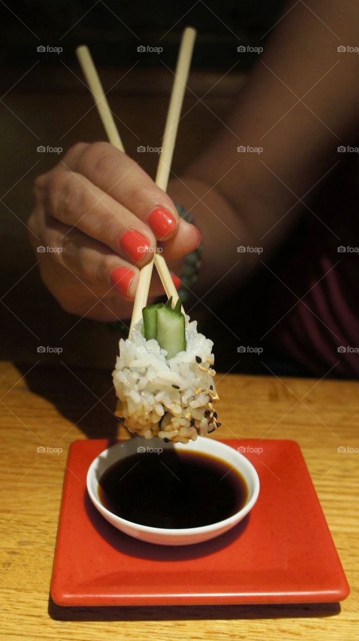 A person holding sushi