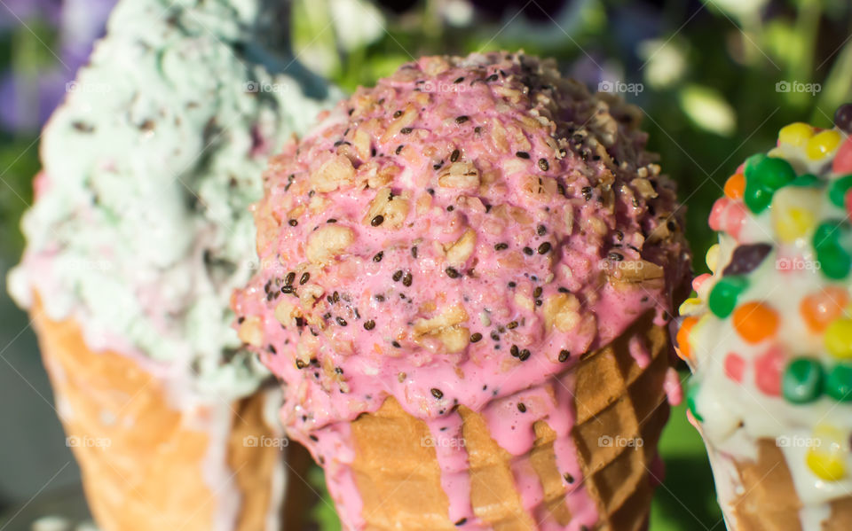 Pink ice cream scoops in cone with healthy sprinkle toppings