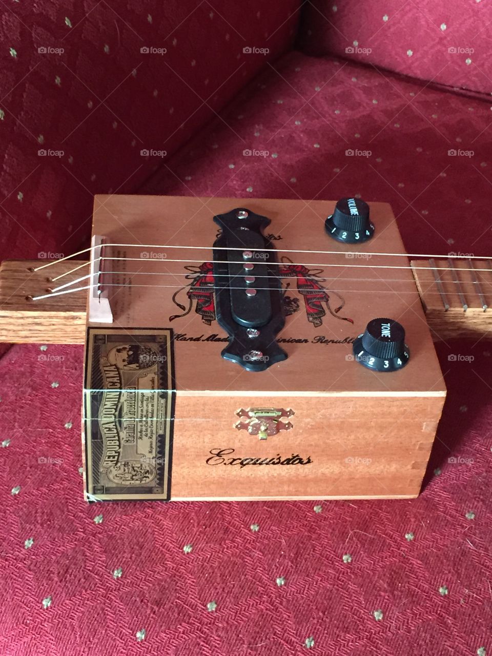 Four string wooded cigar box guitar.