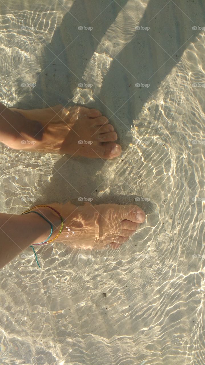 Feet under the clear water of The Caribbean Sea