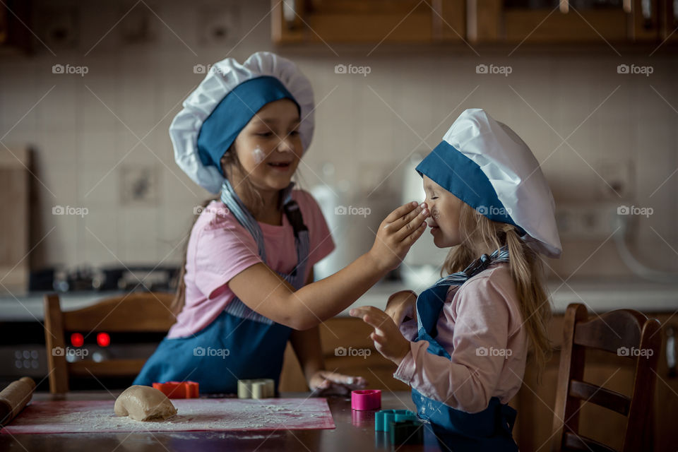 Little sisters cooking the biscuits 