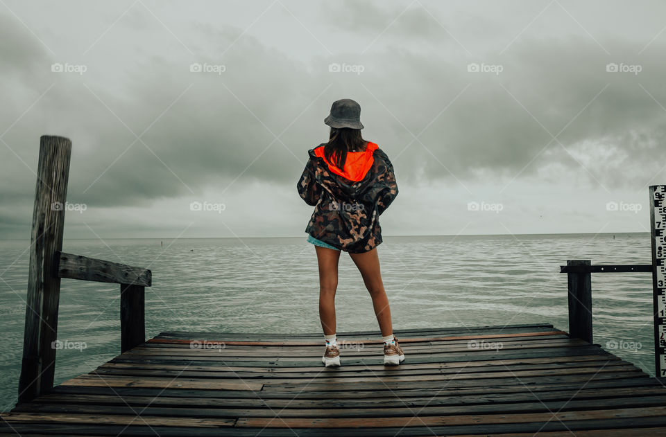 girl on the pier watching the sea