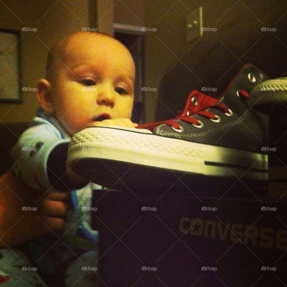 Baby boy getting daddy's shoe