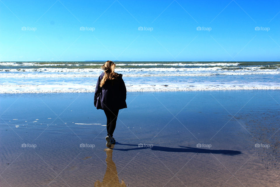 Rear view of a woman walking on beach