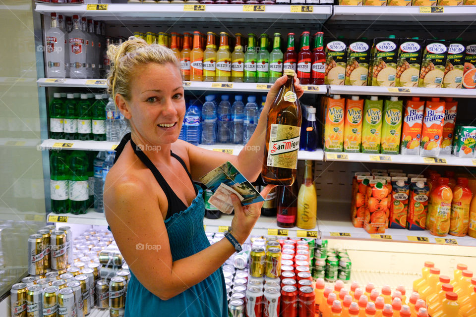 Woman of 30 years of age is buying alcohol in a local supermarket in Alcudia, Majorca.