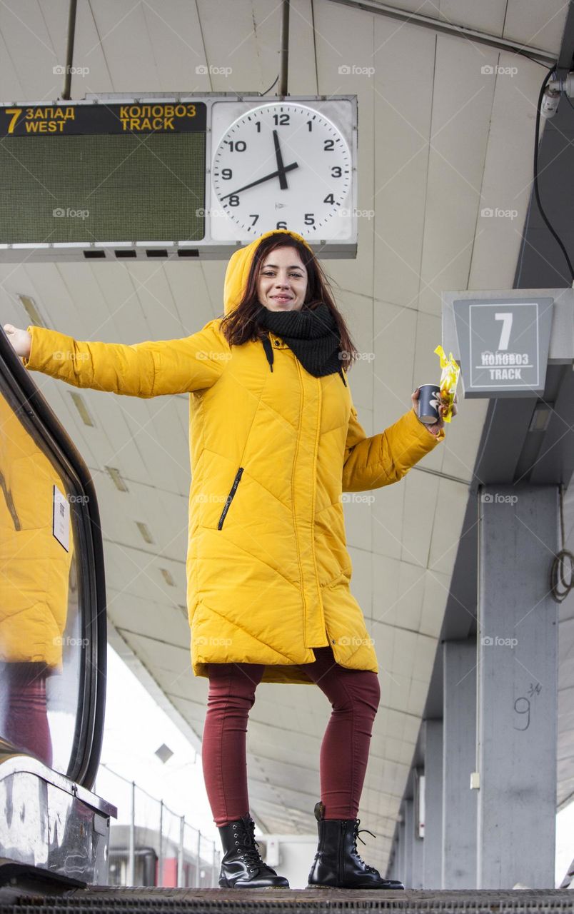 Young woman in yellow jacket on the station