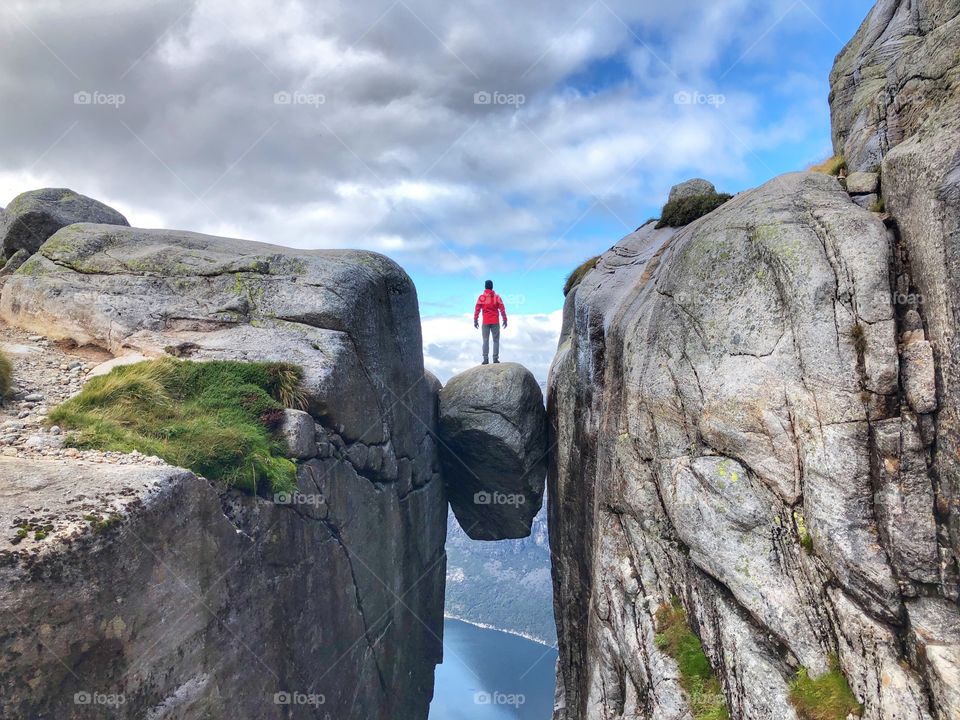 A man standing on a rock in mountains, Norway Kjeragbolten