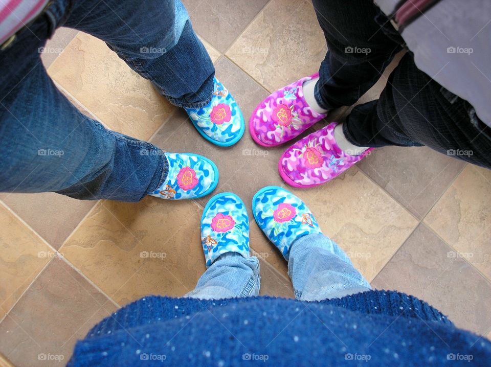 Three girls in slippers standing in a circle