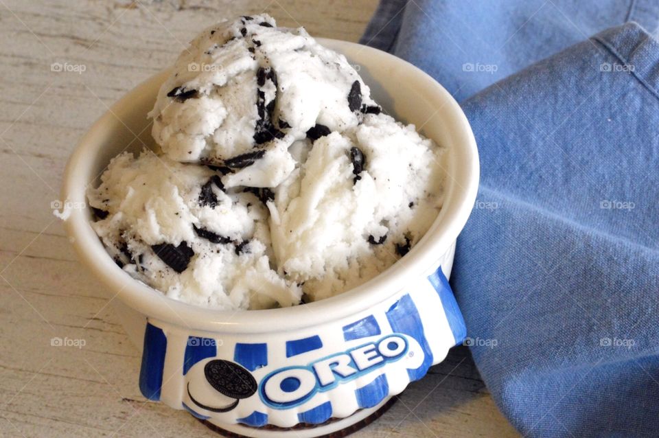 Oreo cookie ice cream flat lay on a white rustic background with a blue towel 