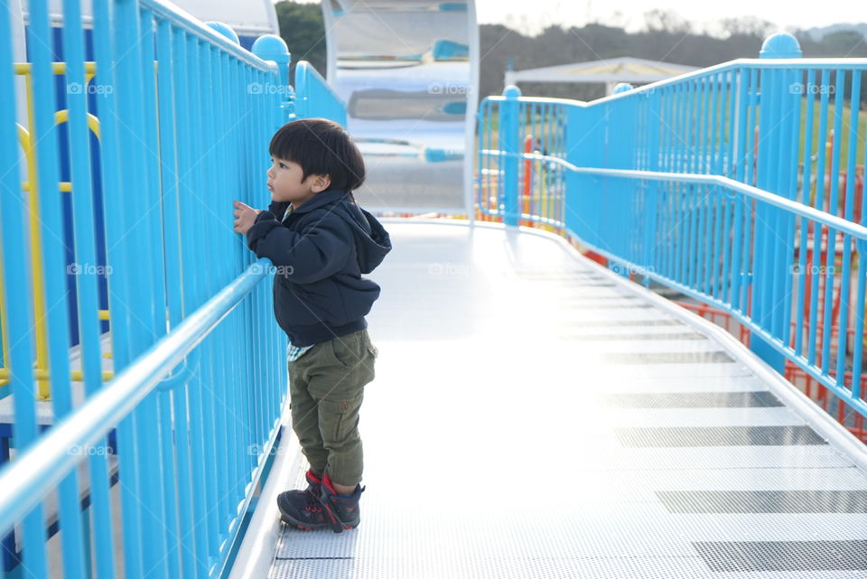 Japanese boy holding the fence