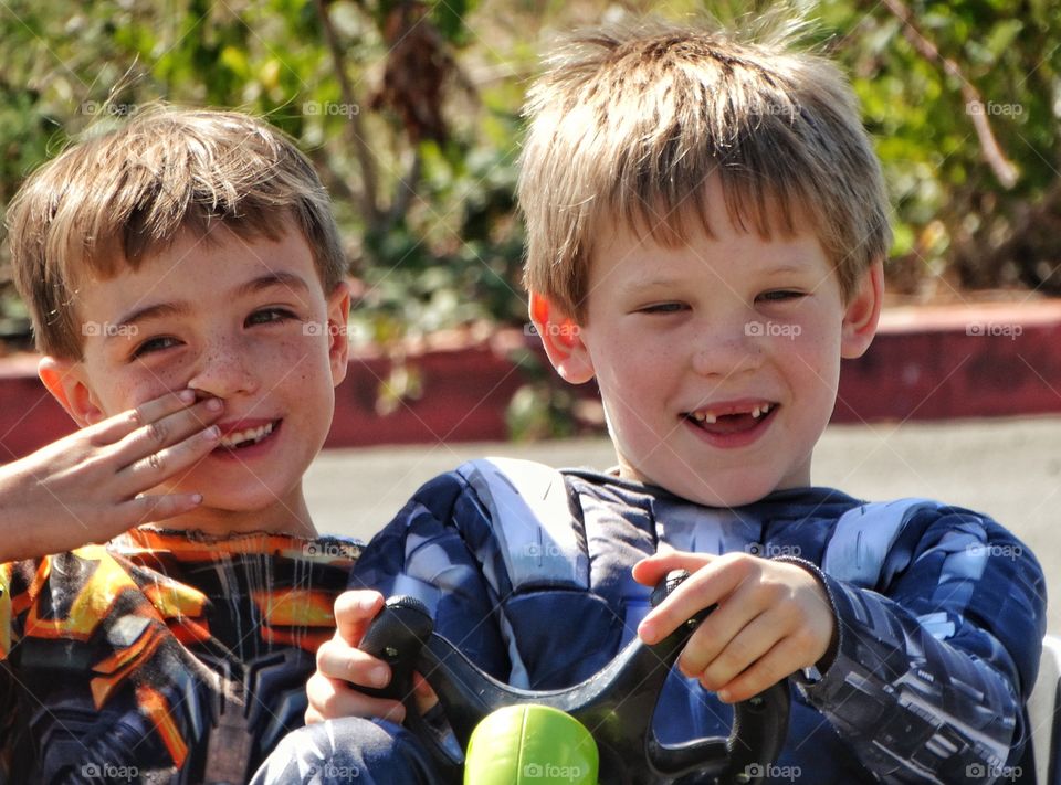 Pure Joy. Young Boys Behind The Wheel Of S Toy Race Car

