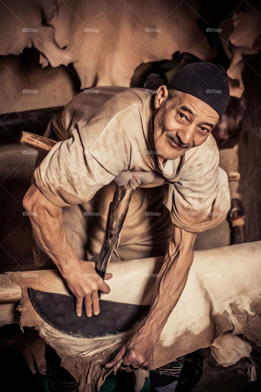 Old man working with animal skin