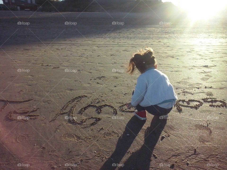 Dibujo en la arena, mi niña dibujando. unens