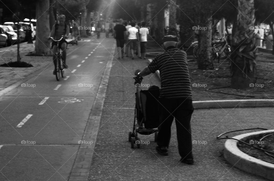 Old man walking around with a stroller
