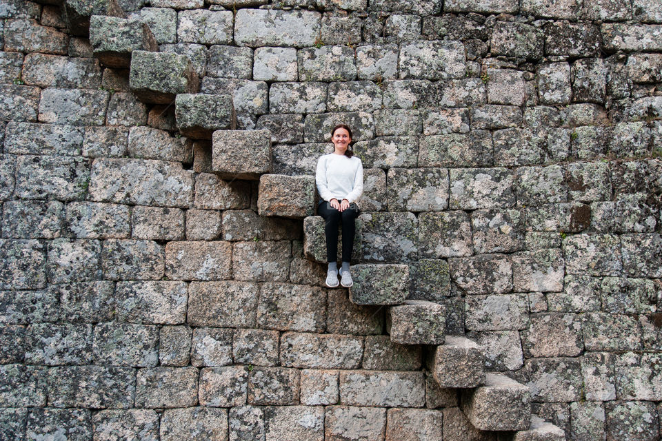 Girl sitting on the steps of a huge medieval staircase.