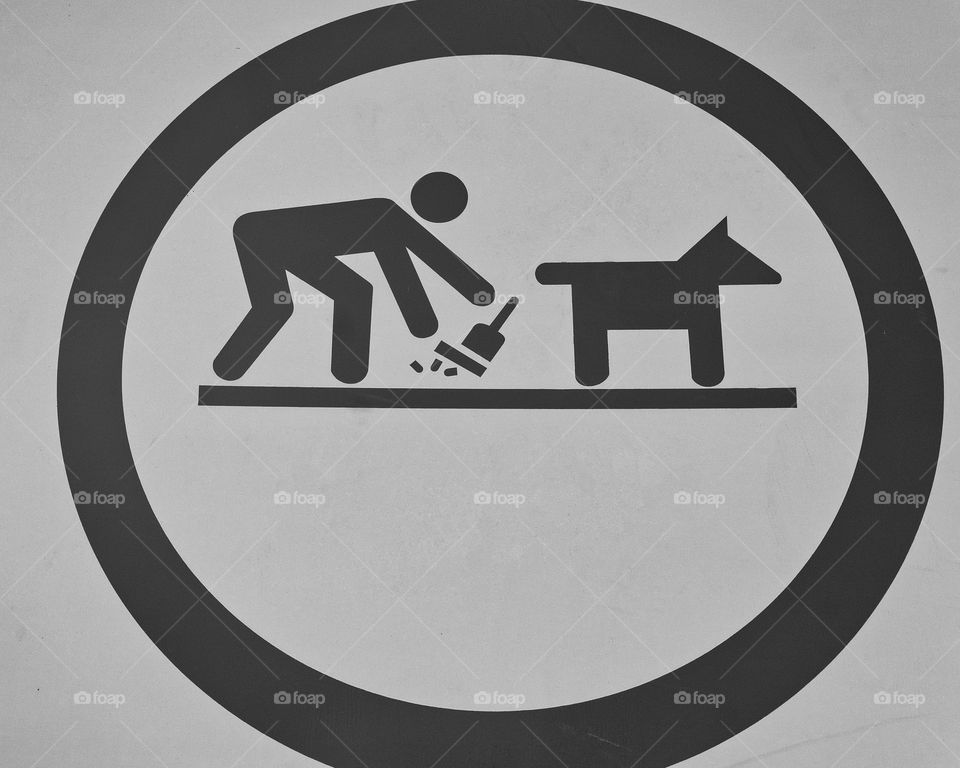 Image of a public park sign illustrating a person cleaning up their dog’s poop.