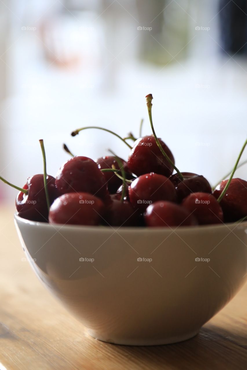 Fresh cherries close up in a white bowl