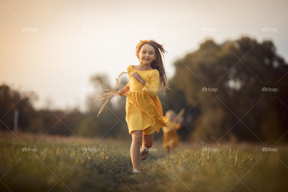 Little girl in yellow dress outdoor portrait 