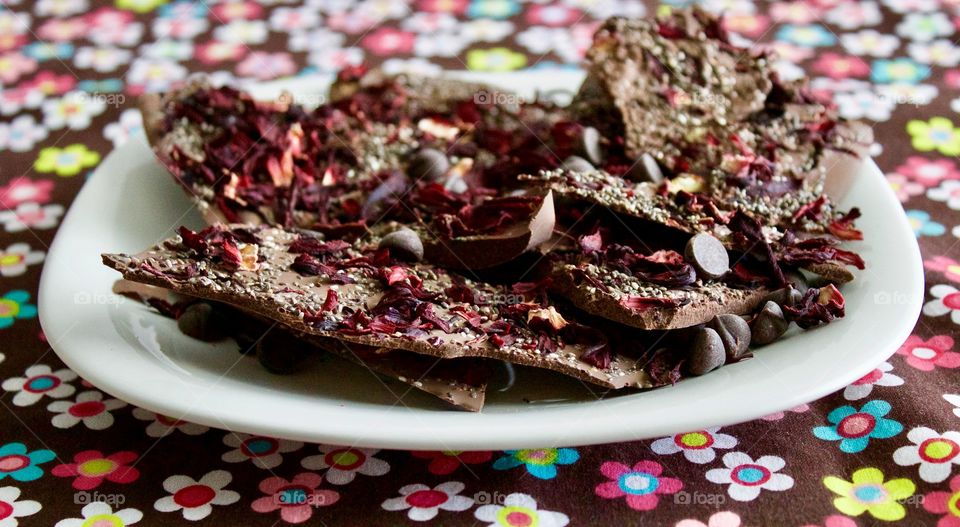 More Chocolate - Hibiscus Chia Chocolate Bark on a white plate, bright floral tablecloth