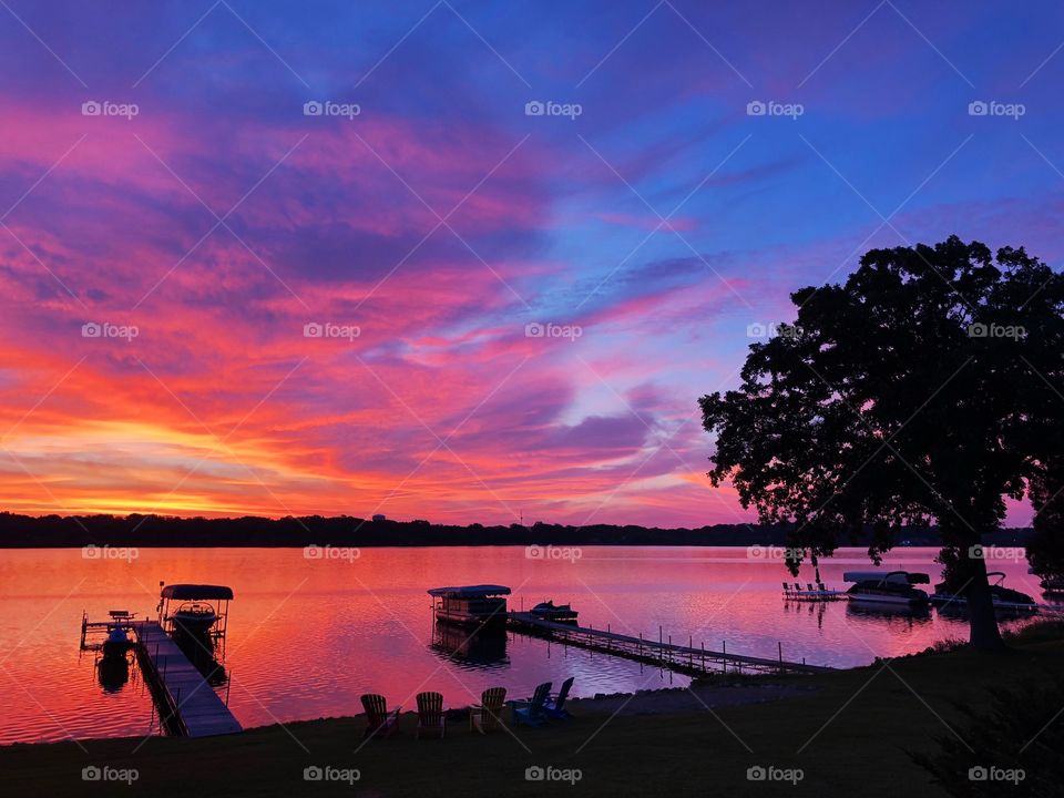 Lakeshore Silhouetted against Colorful Sunrise Painting the Sky over Minnesota Lake 
