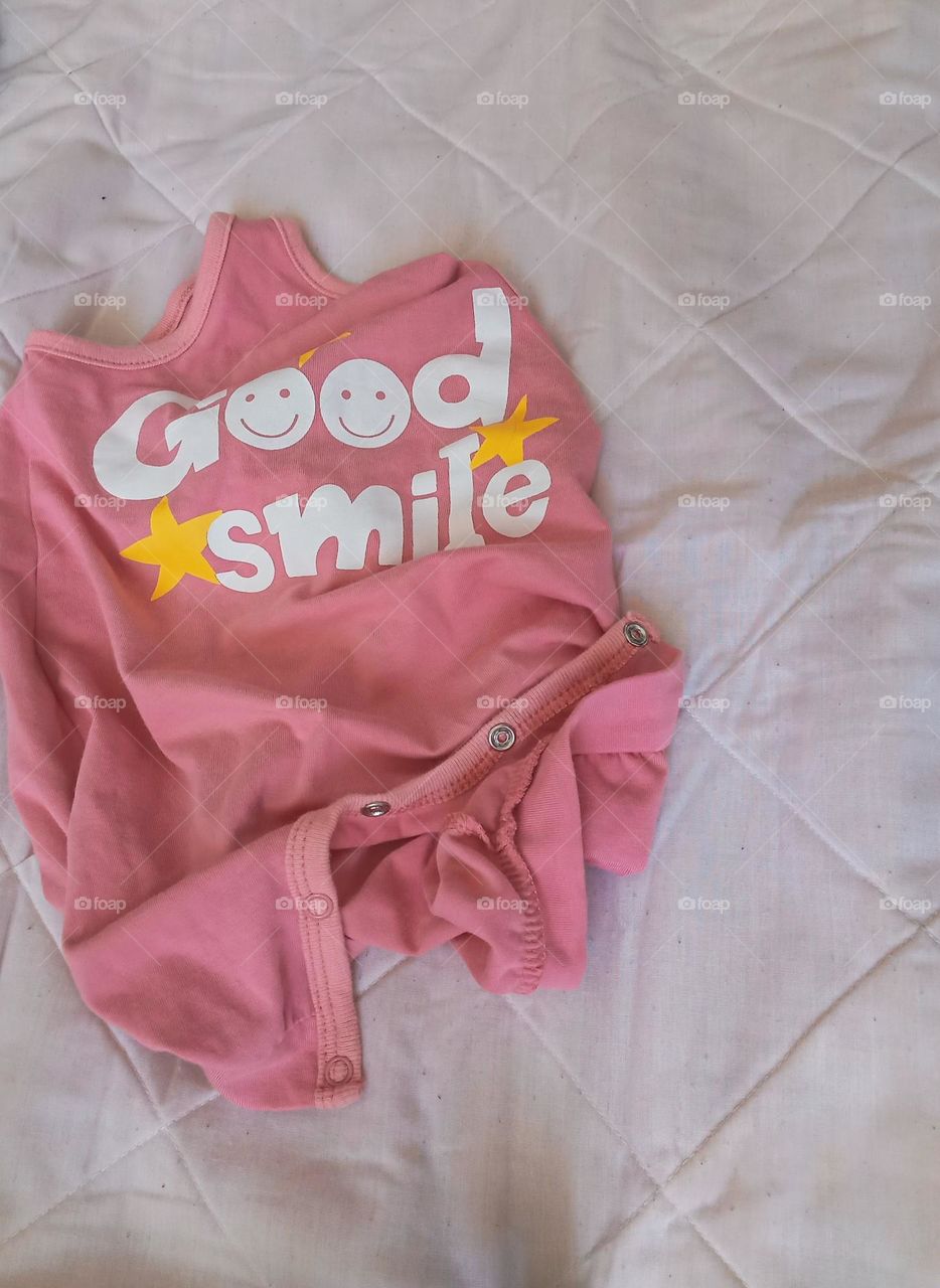 printed pink baby clothes on a white background