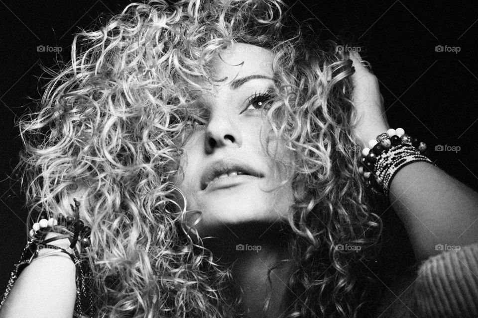 Pretty woman. Beautiful girl with curly hair looking outside black-and-white