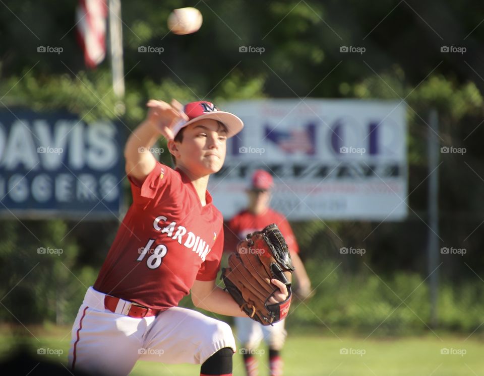 Youth baseball player pitching in game