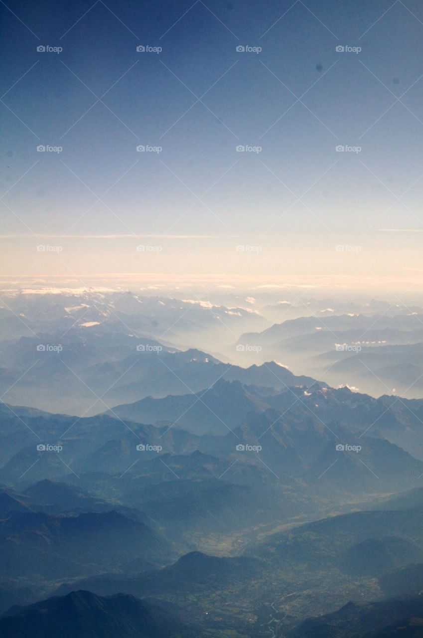Peaks over the clouds . View from my plane window of the alps 