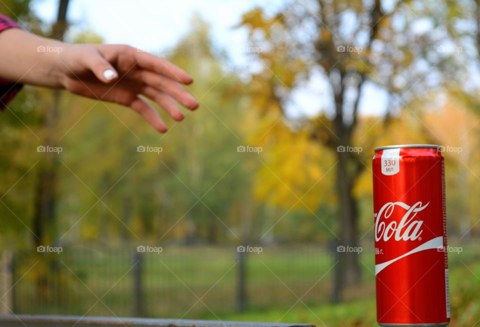 coca cola and hand outdoor, park background