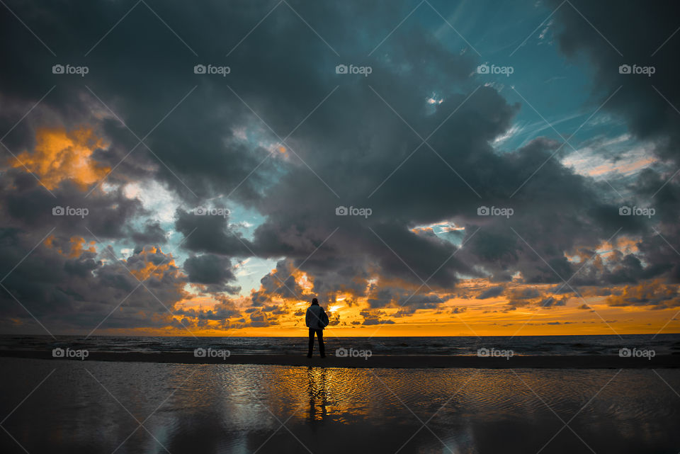 Beautiful sunset and silhouette of man with backpack
