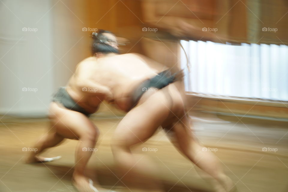 Japanese Sumo wrestlers battling in a training stable