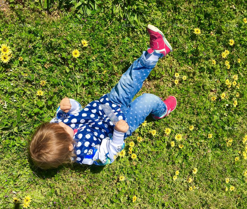 Young child rolling in the grass
