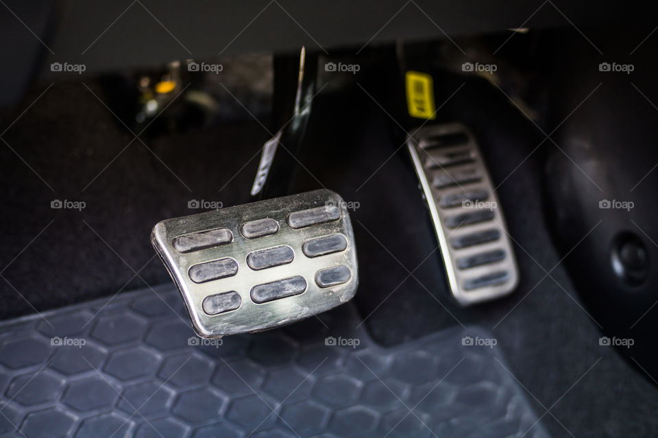 Steel pedals of a car with an automatic transmission, gas and brake pedals close up