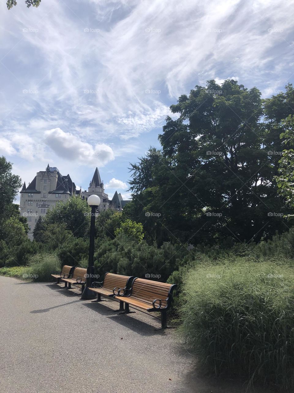 Bench at the park in metal and wood and the old building in the background 