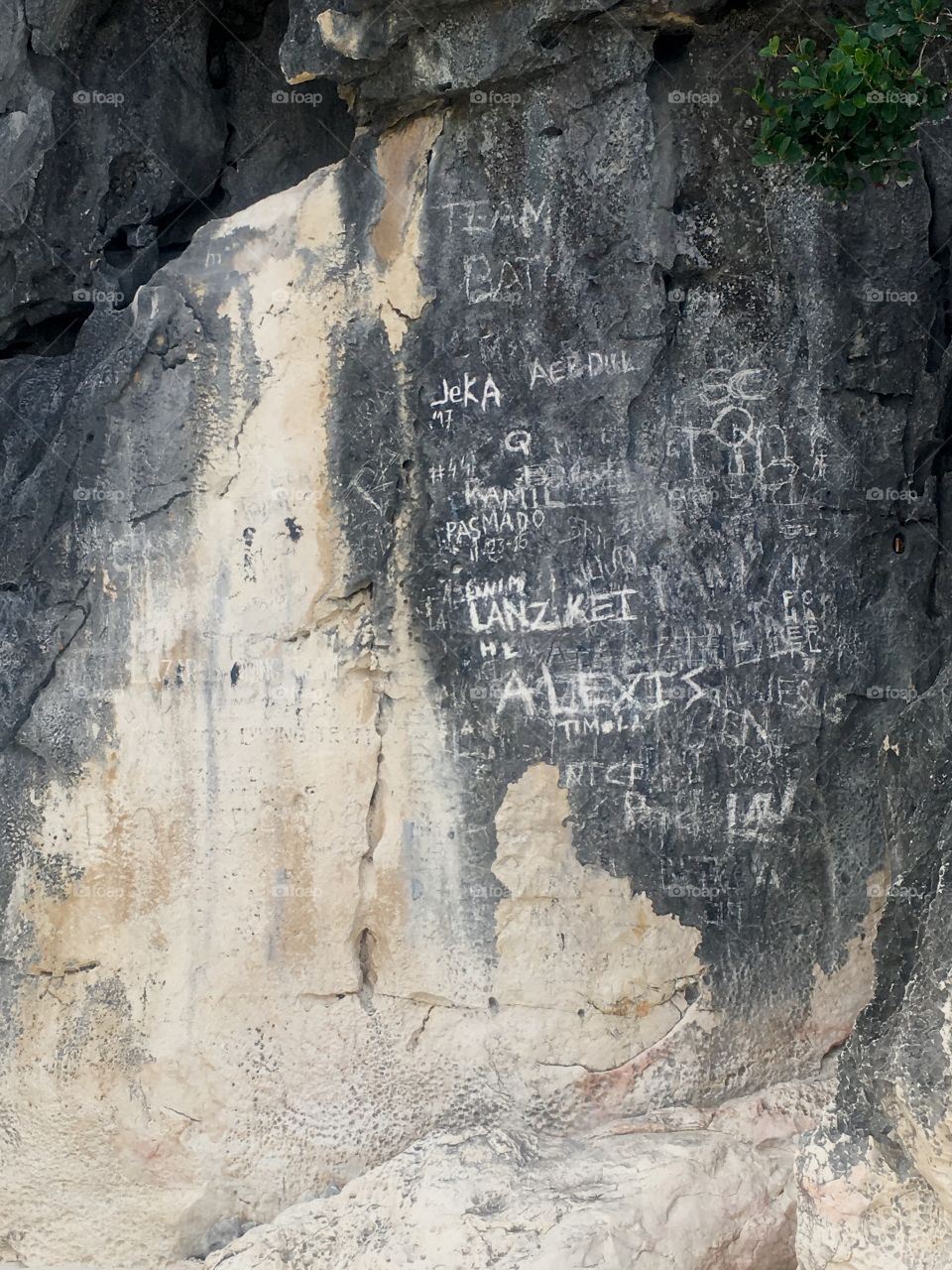 Names carved into the side of a rock 