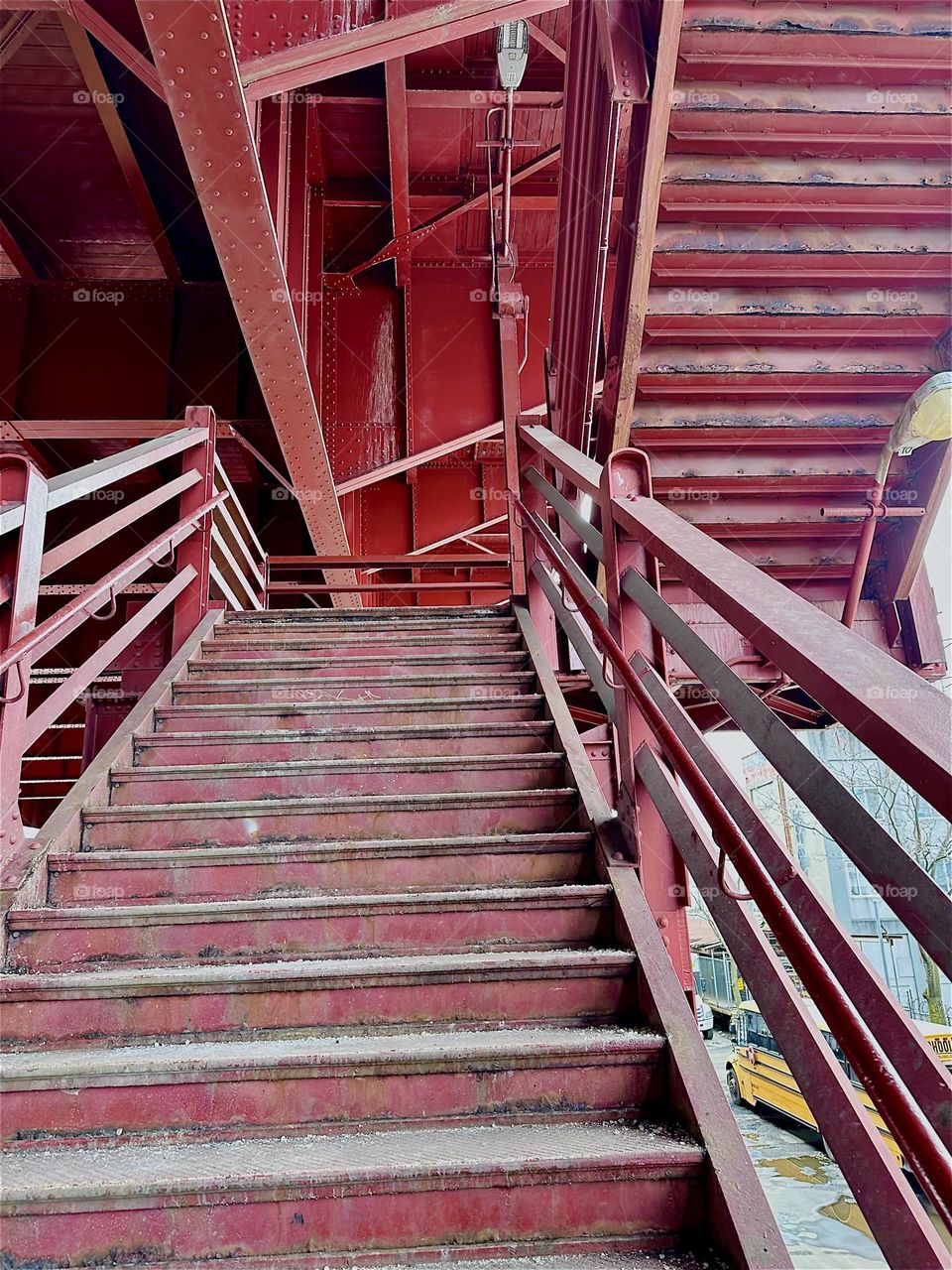 This is the red metal staircase that leads up to the pedestrian lane of the “Pulaski Bridge” at “Newtown Creek” that connects LIC, Queens to “Greenpoint”, Brooklyn. 2024. Hypnotic Productions