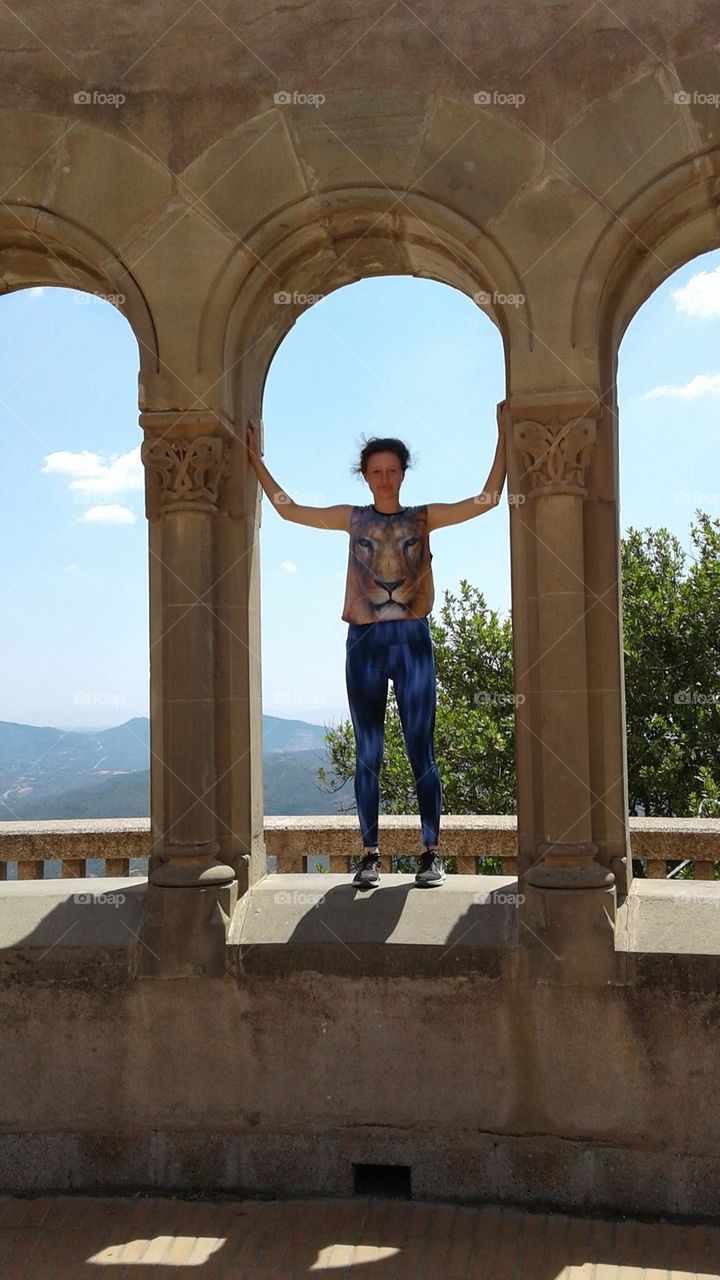 Standing in a large archway overlooking a giant valley in Monserrat, Spain. Fun tourism.
