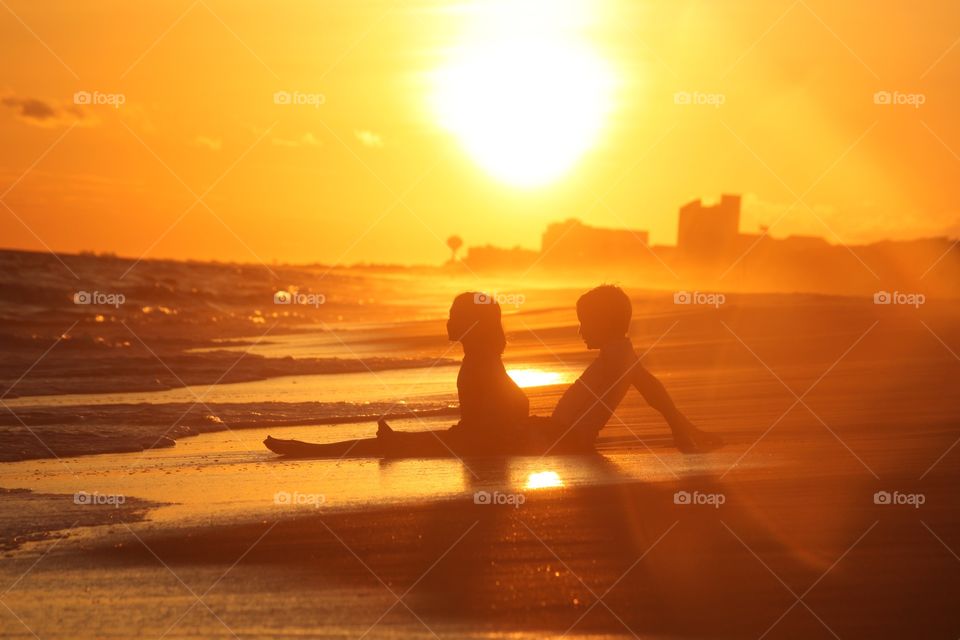 Two child sitting at beach