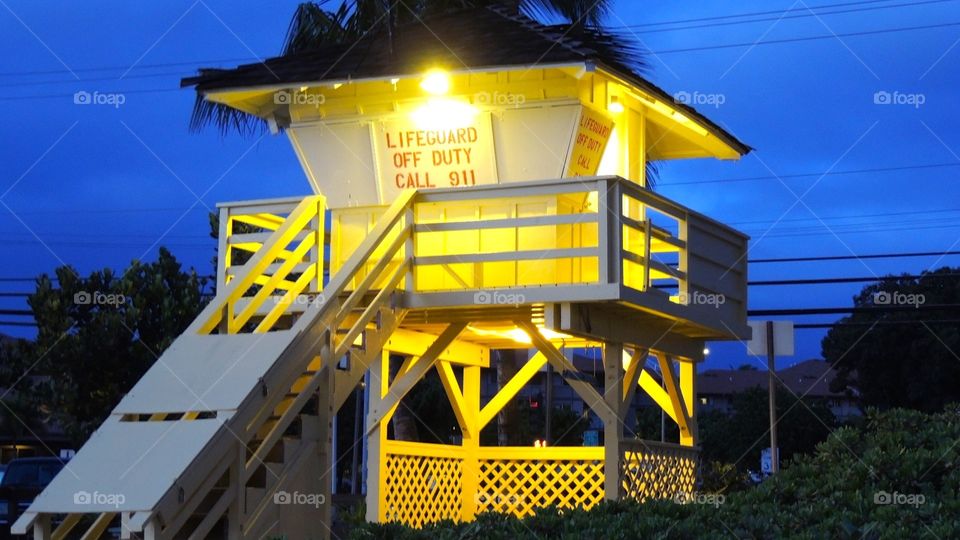 Yellow lifeguard shack . A yellow lifeguard shack on the beach at night