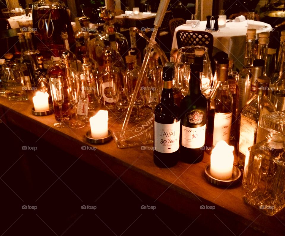 A romantic long table with candle light and collection of special spirits. Grappa, cognac, armagnac or amaro. A wonderfull collection. Oak table gives a natural feeling of heat and passion. The light gives for this warm atmosphere the rest. 
