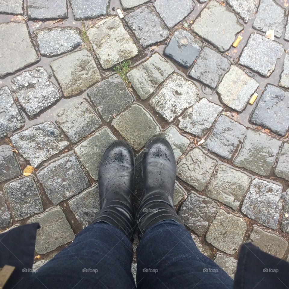 Rainy feet. Feet in boots with cobblestones on a rainy day in Prague