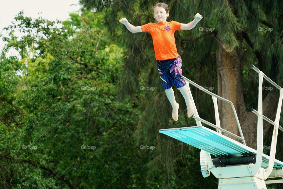 Boy Leaping Into A Pool