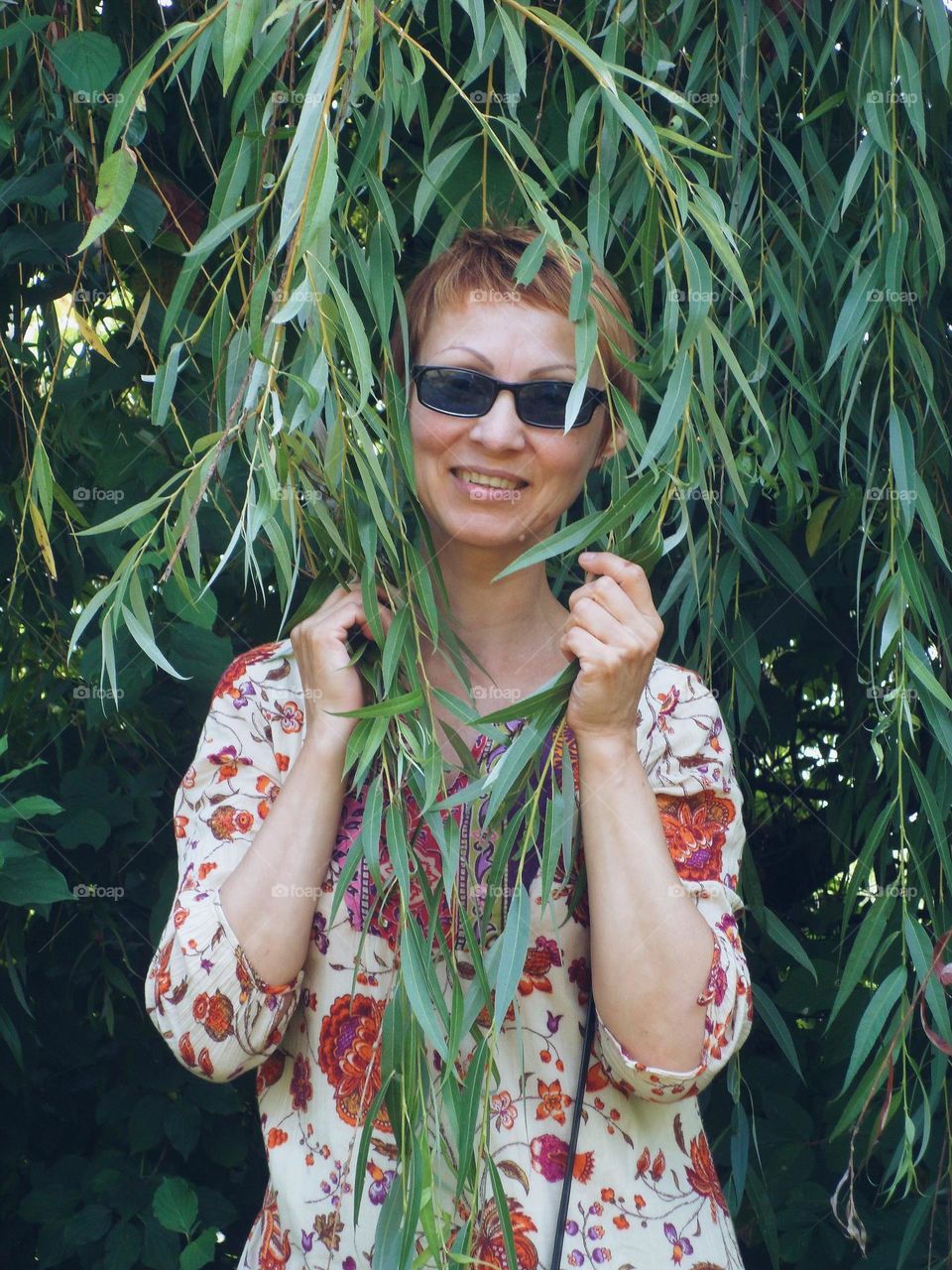 portrait of a girl with glasses on a background of foliage