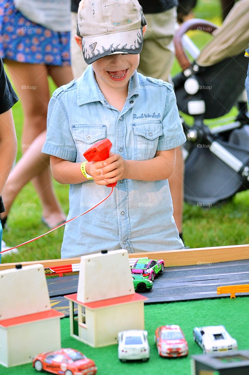 Boy playing. Boy driving cars on a car track