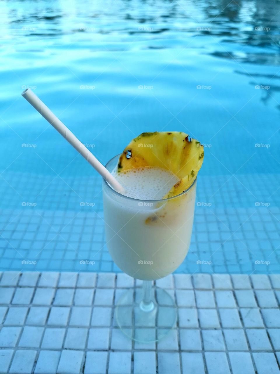 Pina Collada cocktail in a swimming pool. Water - amazing blue colour. Relax and enjoy your time in a holiday. Summer, travel, dreams and rest. Tasty, yummy, delicious drink.
Unusual shooting angle. Shooting from below. Down up. From the ground up...