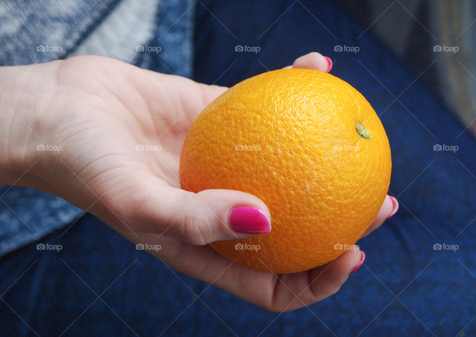 The woman's holding an orange