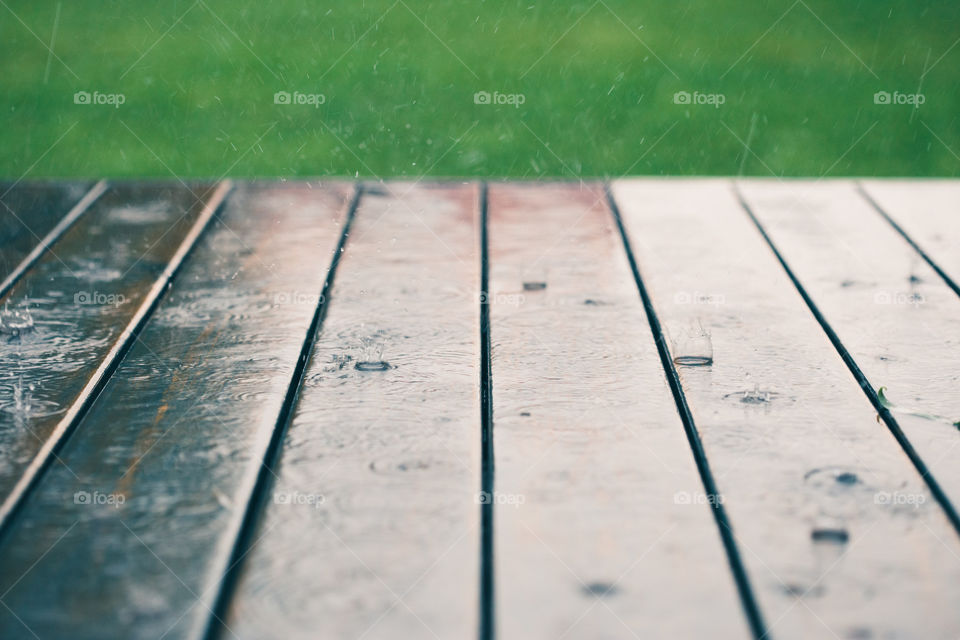 Closeup of wood planks while raining in perspective. Background of wooden natural surface and raindrops