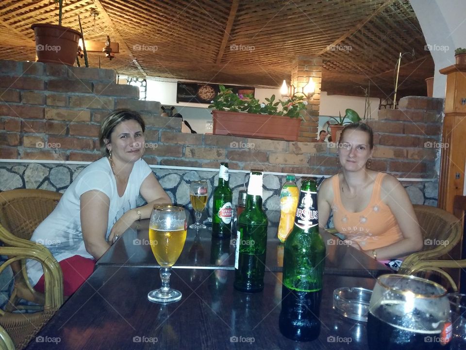 Two friends drinking beer in restaurant