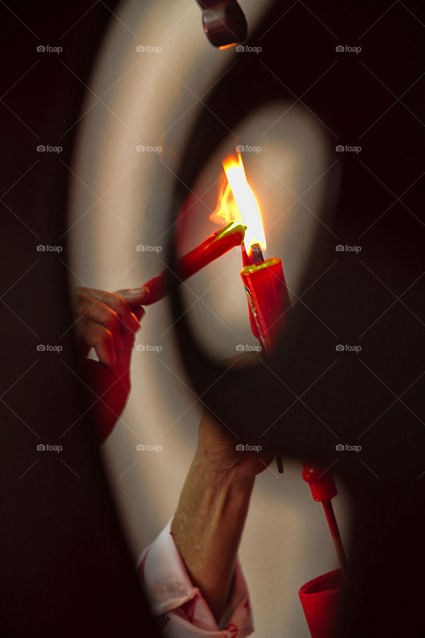 Close-up of hand Igniting candle