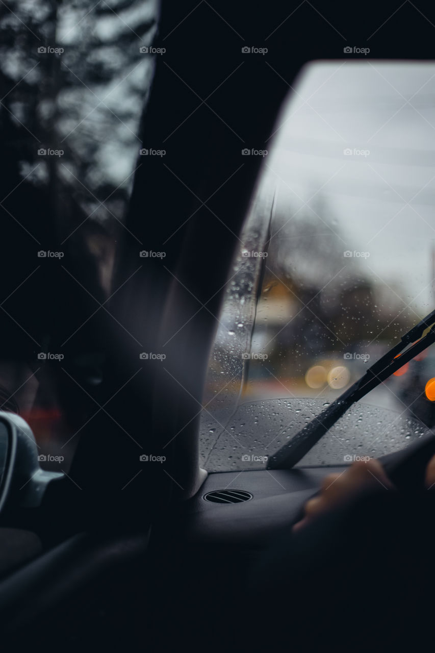 Raindrops and traffic lights seen through windshield